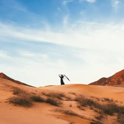 Woman standing on sand dunes in the Amaala desert