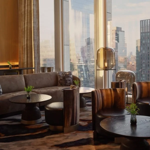 Modern lounge with curved sofa, woodgrain armchairs, city view and foliage on round tables