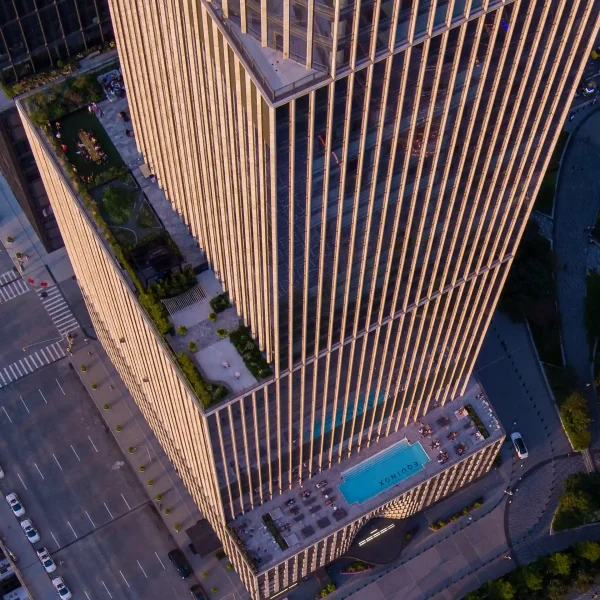 Aerial view of Equinox rooftop pool with lounge chairs, landscaped terrace, and sleek high-rise facade