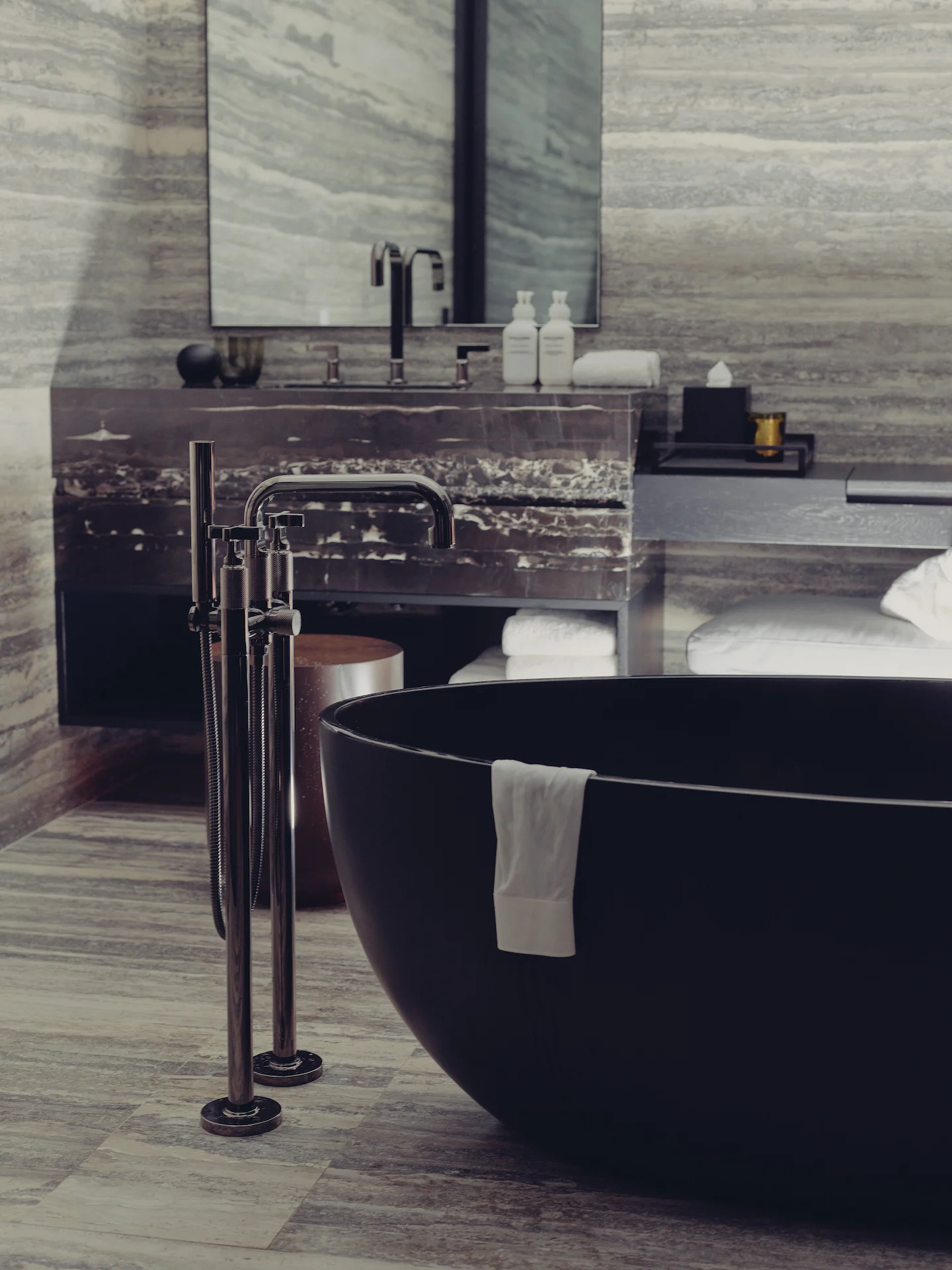 Luxurious bathroom with matte black tub, striped stone walls, and marble vanity, evoking spa-like serenity and modern indulgence