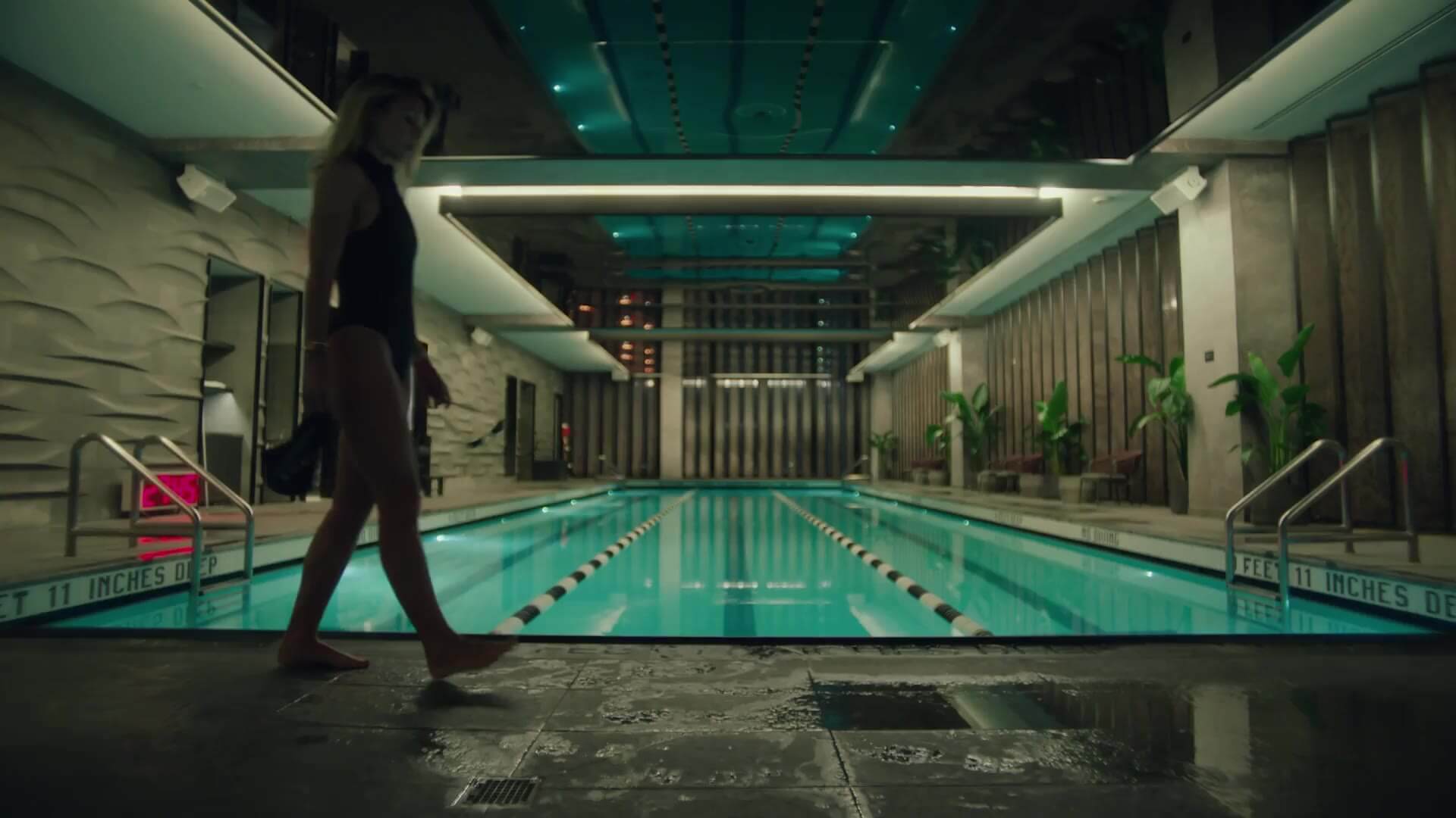 Indoor lap pool with elegant lighting, textured walls, and deep end marked at 11 feet 11 inches.