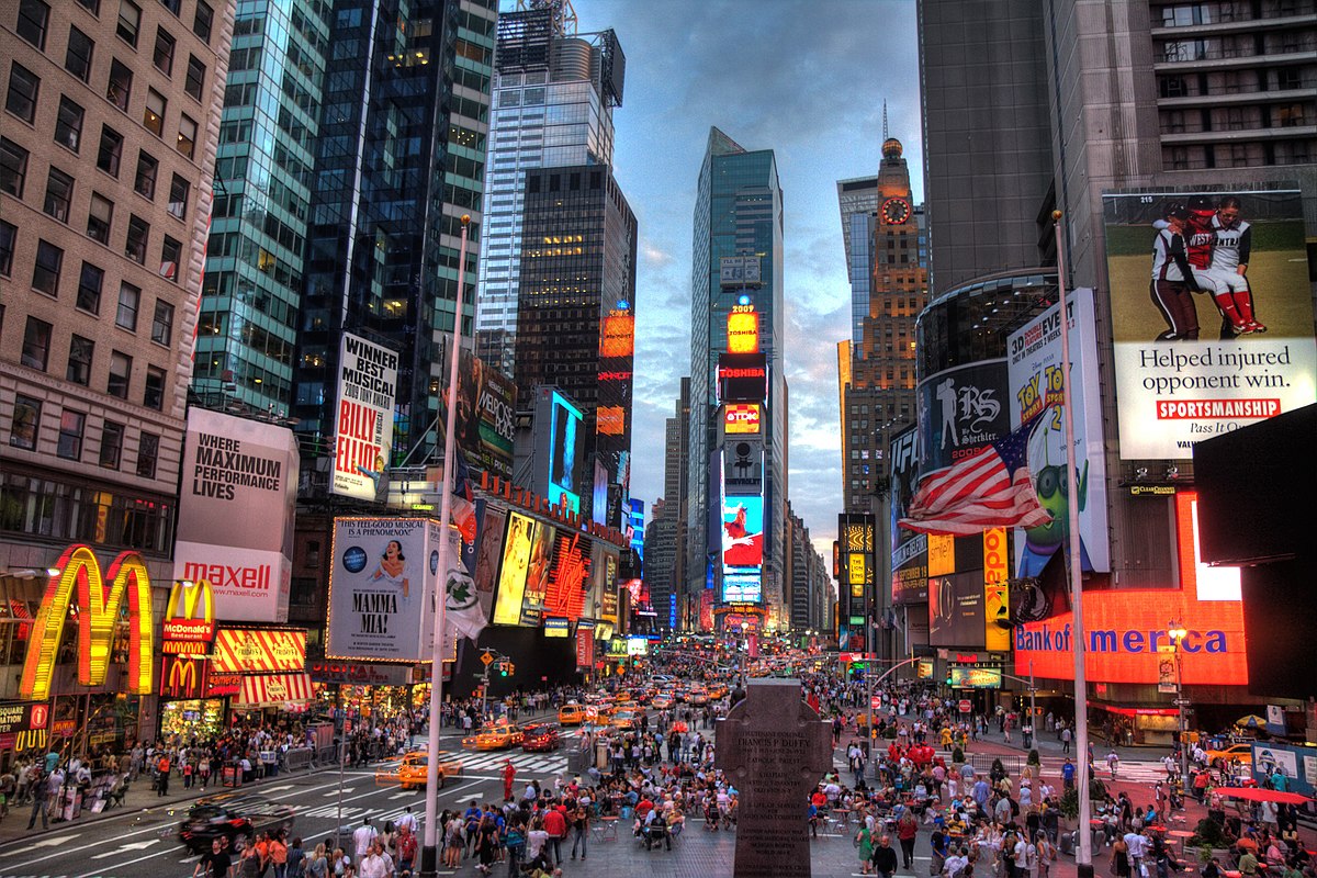 Times Square at night with crowds, taxis, and bright billboards including McDonald's and Coca-Cola.