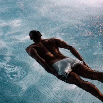 Guest swimming underwater in luxury pool at Equinox Hotel NYC, showcasing serene ambiance and modern design details.