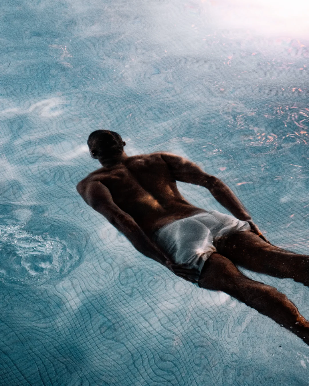 Guest swimming underwater in luxury pool at Equinox Hotel NYC, showcasing serene ambiance and modern design details.