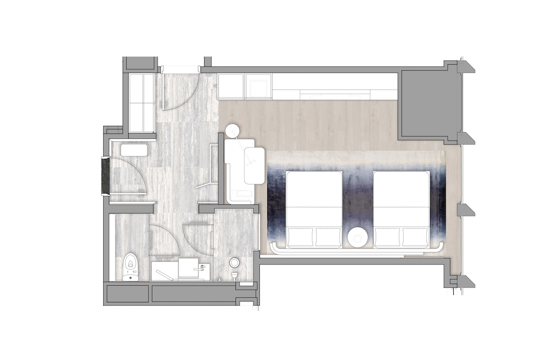 Twin-bed layout with desk, lounge corner & full bathroom, perfect for short stays or shared accommodations.