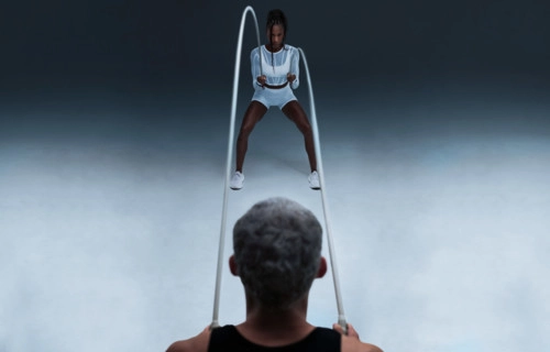 Two people doing jump rope exercise, rope mid-air, set against gradient background emphasizing motion and coordination