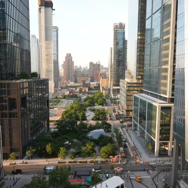 Modern cityscape with glass skyscrapers framing central green space, blending architecture with urban nature