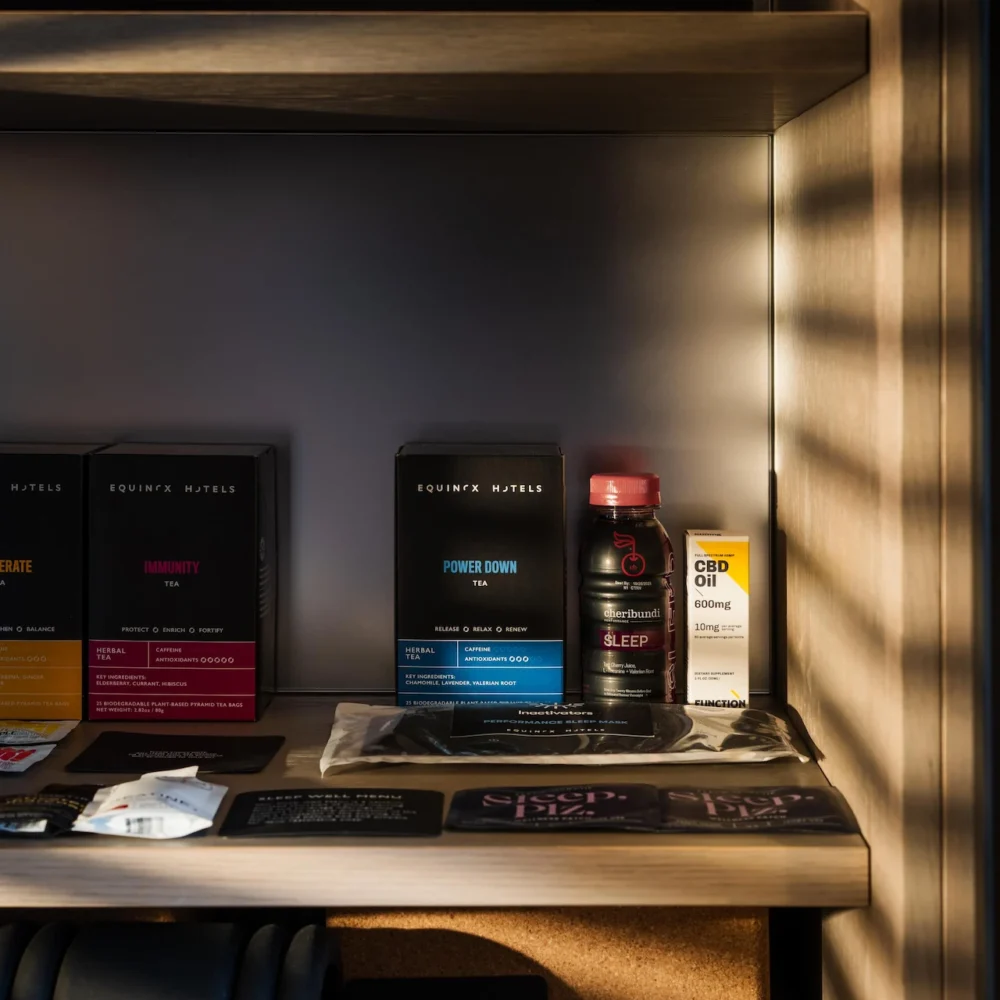 Shelf at Equinox Hotel with wellness products including Power Down, Immunity, CBD Oil Sleep, foam roller, and cork yoga block