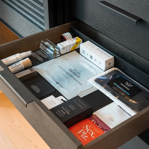 Drawer with curated wellness products including CBD drops, sleep aids, face masks, and supplements in a luxury hospitality setting