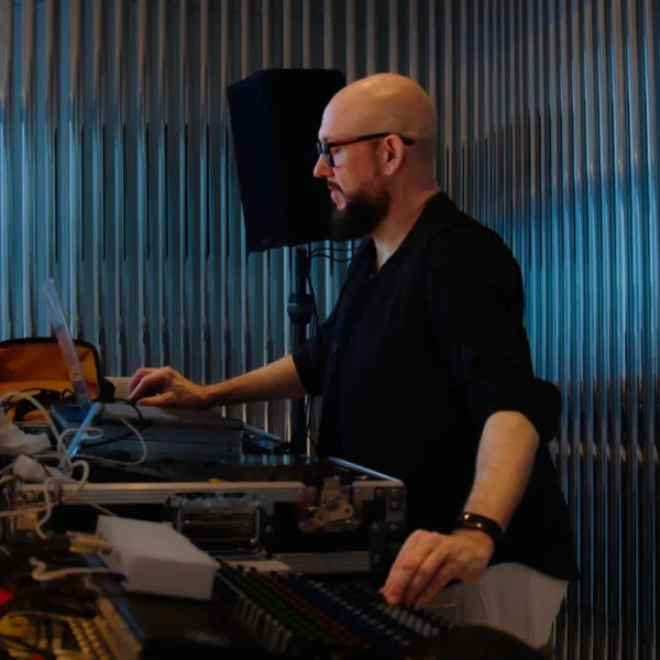 Tom Middleton at the Global Sleep Symposium at Equinox Hotel, operating audio equipment in an industrial-style.