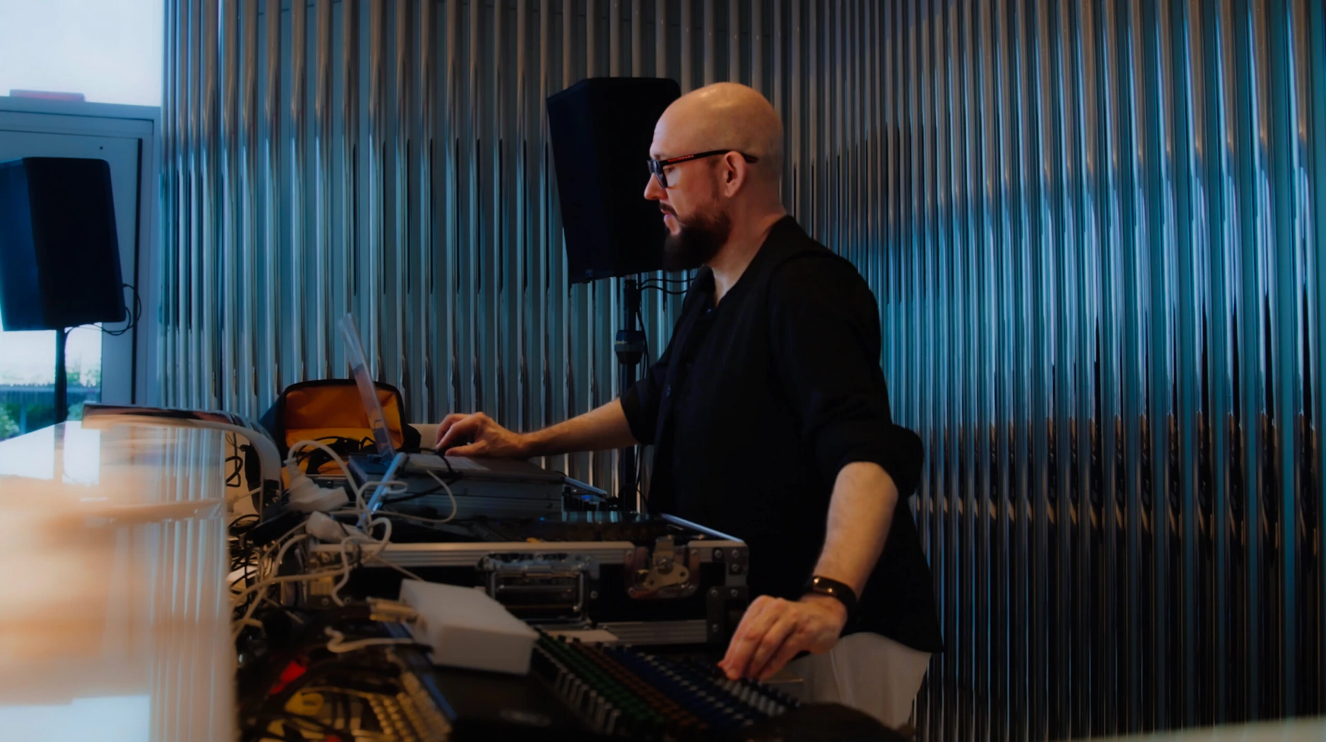 Tom Middleton at the Global Sleep Symposium at Equinox Hotel, operating audio equipment in an industrial-style.