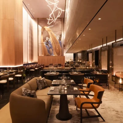 Upscale restaurant interior in New York City with elegantly set tables, warm ambient lighting, and striking abstract wall art, evoking a refined dining ambiance that blends sophistication with artistic charm.