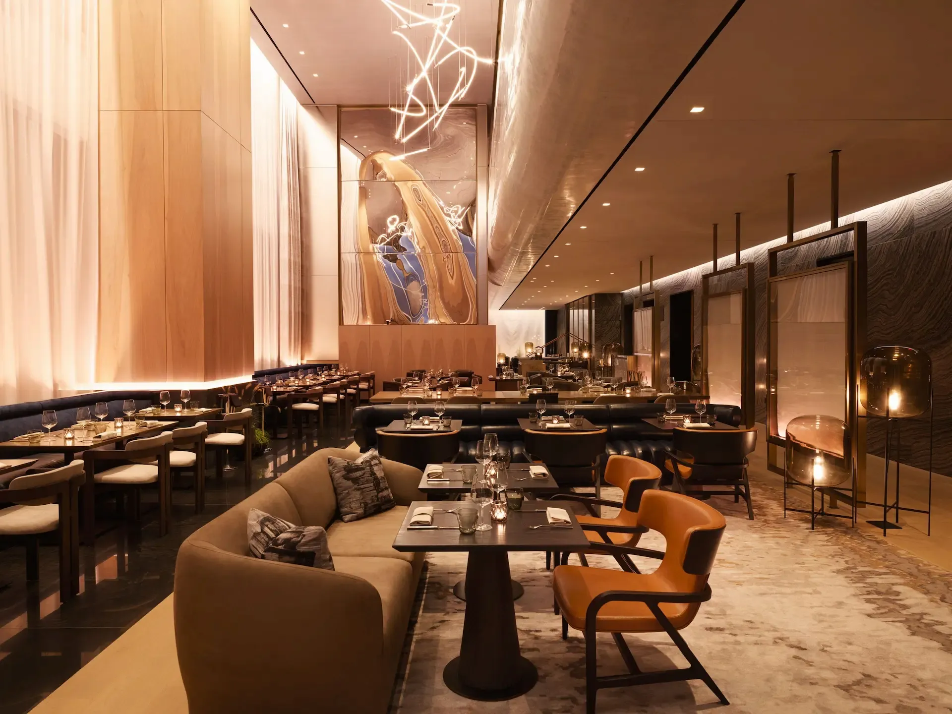 Upscale restaurant interior in New York City with elegantly set tables, warm ambient lighting, and striking abstract wall art, evoking a refined dining ambiance that blends sophistication with artistic charm.
