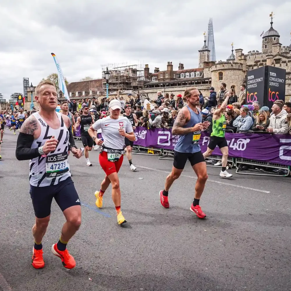 Marathon runners racing through central London with Tower of London and Shard in background