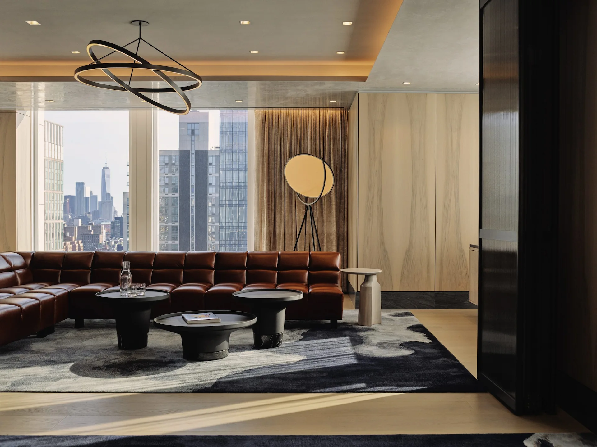 ElectricLemon Private Dining Lounge Space with leather sectional sofa, city skyline view, and geometric chandelier