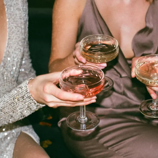Guests holding champagne coupes while celebrating New Year’s Eve together