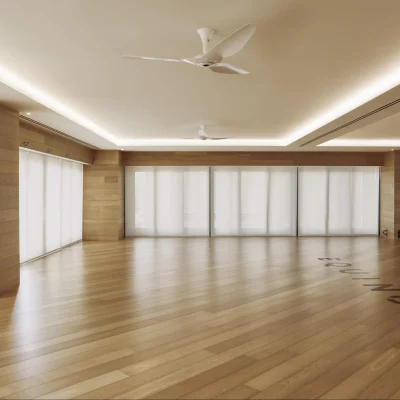 Minimalist wellness room with wooden floors, sheer curtains, ceiling fans, and soft ambient lighting