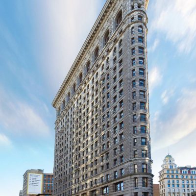 Flatiron Building in New York City with wedge-shaped Beaux-Arts facade and surrounding urban architecture