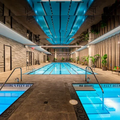 Indoor pool with blue-lit ceiling and hot tubs, evoking luxury and calm