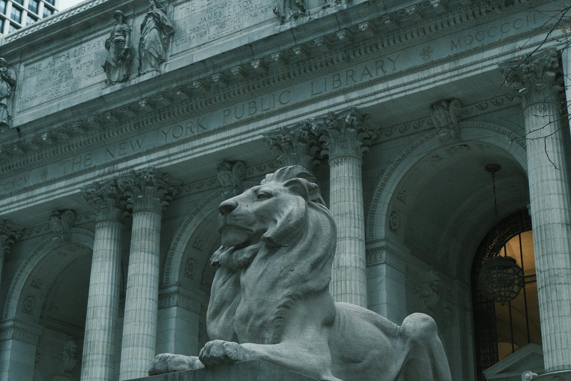 Close-up view of the New York Public Library’s stone facade, featuring carved statues and engraved text honoring the Astor Library above ornate architectural detailing.