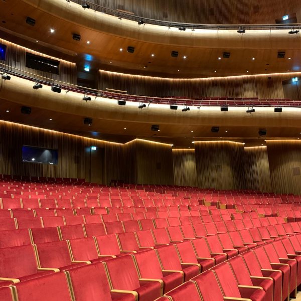 Interior of Lincoln Center theater with rows of red seats and curved wood balconies in New York City