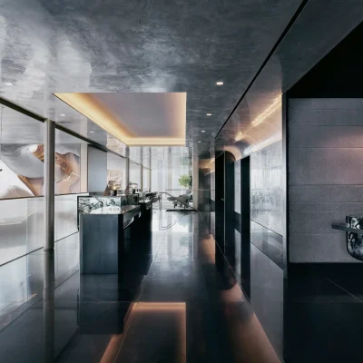 Luxury reception area with glossy black floors, modern lighting, and sleek counters in a minimalist design.