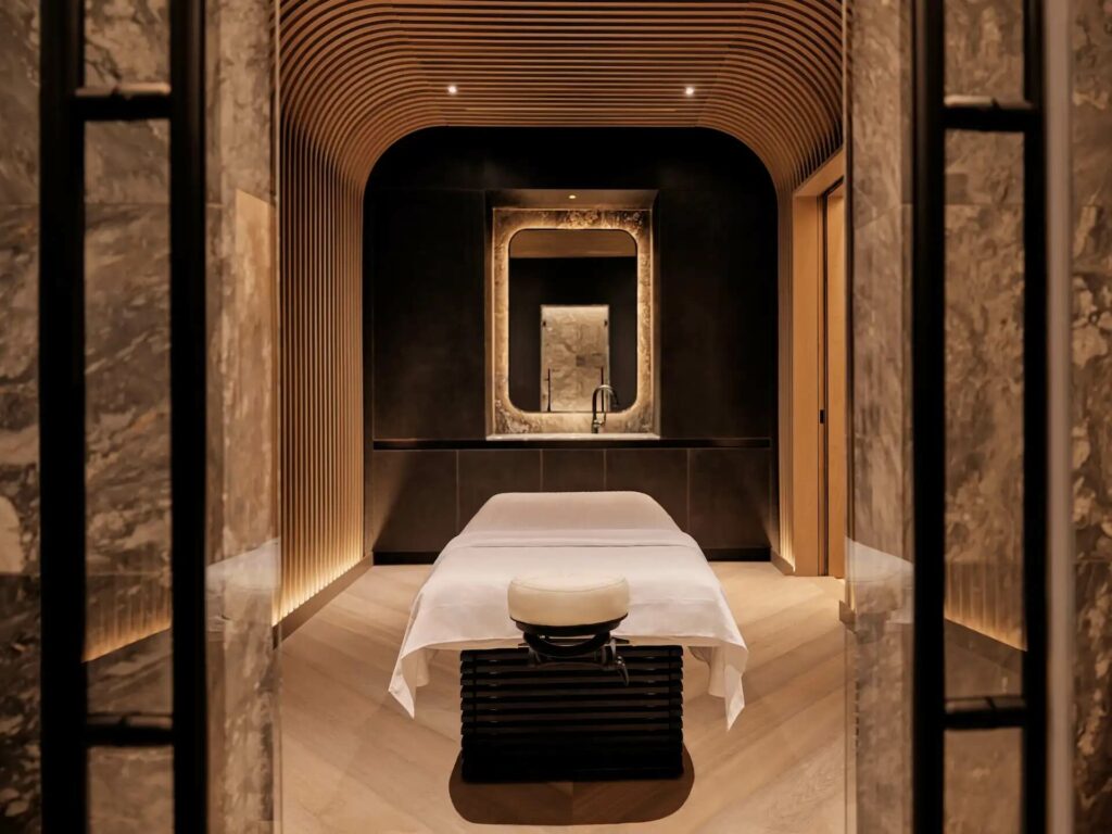 Luxurious spa room with a central massage table and soft ambient lighting.