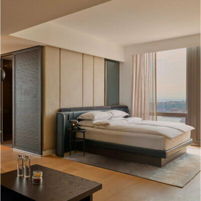 Minimalist bedroom with city view, soft lighting, and clean design.