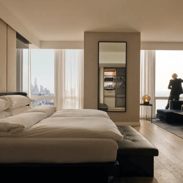 Contemporary high-rise bedroom with city views, layered textures, and a quiet moment by the window.