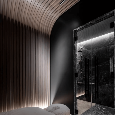 Serene spa room with curved wood accents and marble steam area, designed for immersive relaxation.