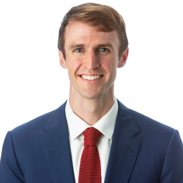 George Groen in a blue suit and red tie, smiling confidently—Director of Hotel Development.