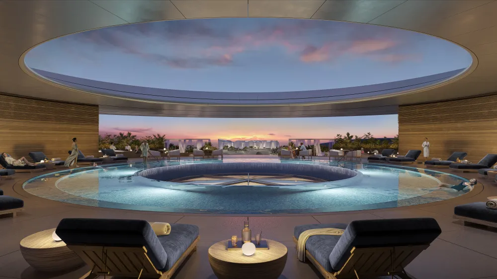 Circular rooftop pool framed by an open ring, sunset skyline view, lounges and cabanas surrounding.
