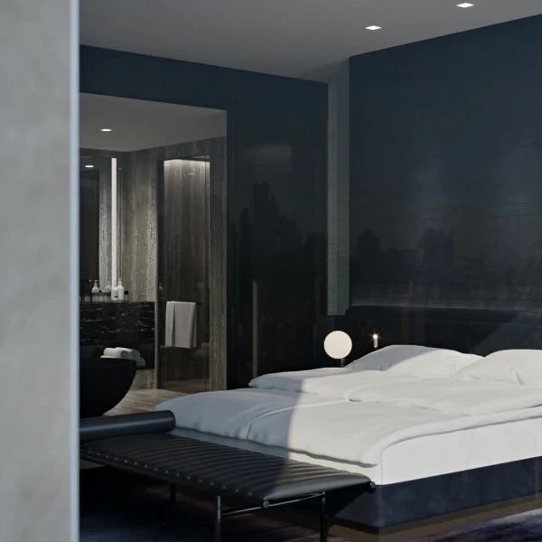 Modern bedroom with dark walls, white bedding, and doorway to bathroom featuring freestanding tub.
