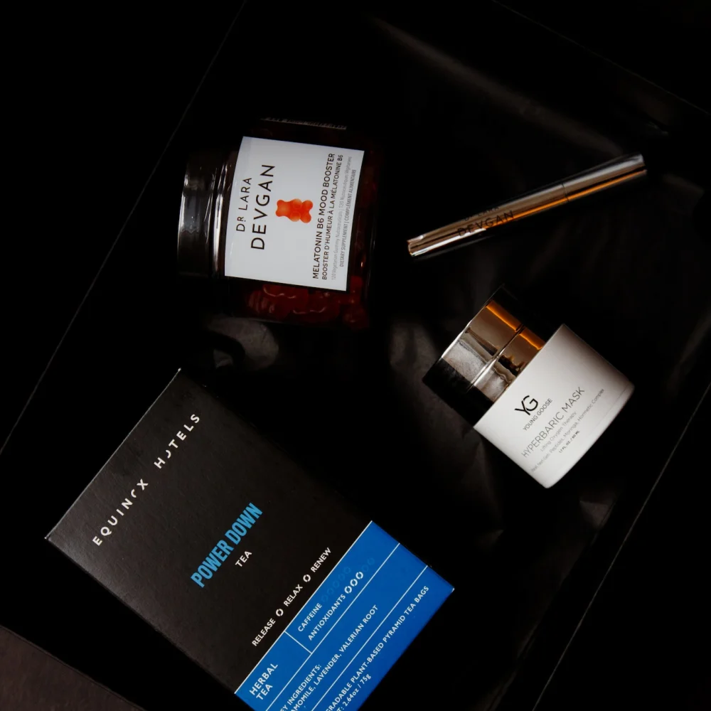 Luxury wellness kit with supplements, skincare, and herbal tea arranged in black box for relaxation