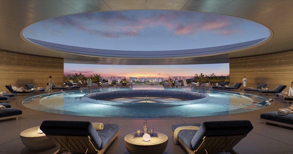 Equinox Amaala indoor pool with central skylight opening to sunset sky, star-patterned floor, cabanas, and guests in robes