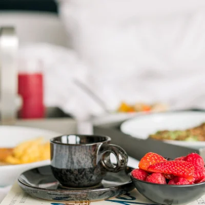 Breakfast in bed. Black cup with strawberries