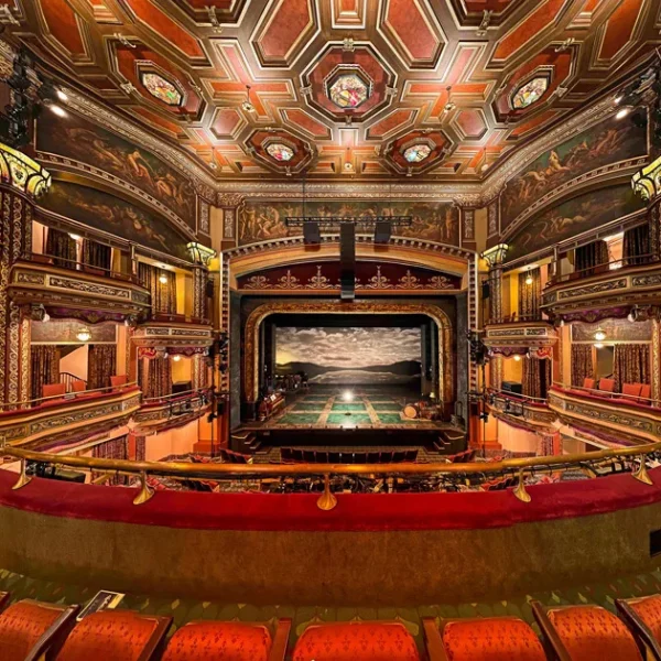 Broadway Theater interior with ornate ceiling, murals, red velvet seating, and scenic stage view from balcony