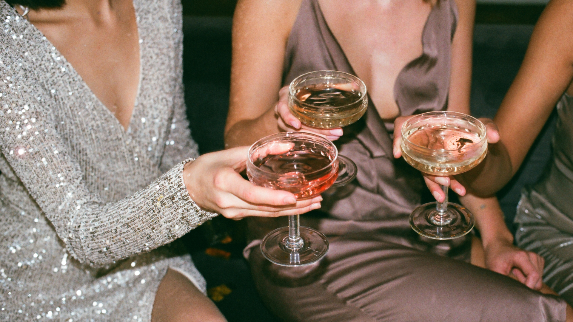 Guests holding champagne coupes while celebrating New Year’s Eve together