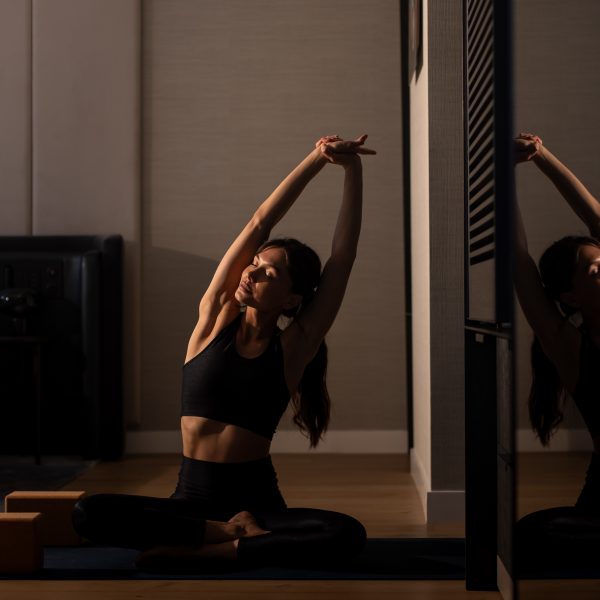 Woman stretching during a yoga session in a serene indoor studio.