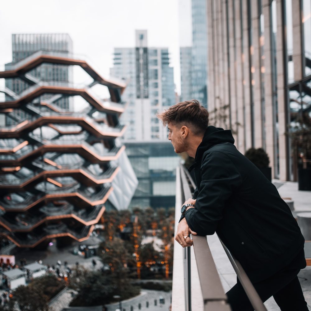 Man overlooking the city from a balcony near Hudson Yards in New York